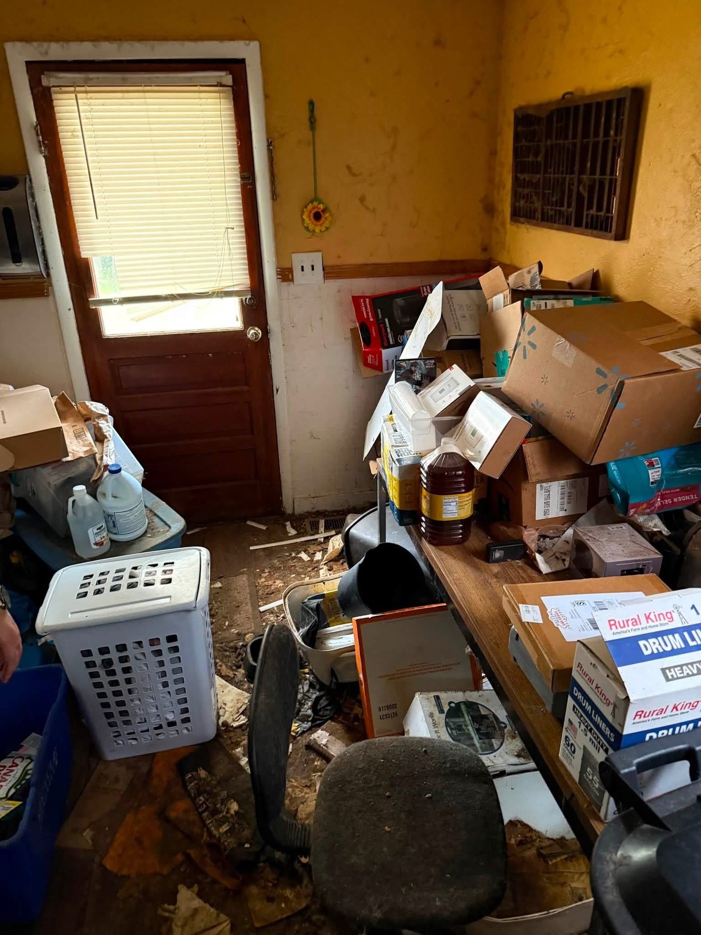Cluttered mudroom filled with boxes and debris before a cleanout