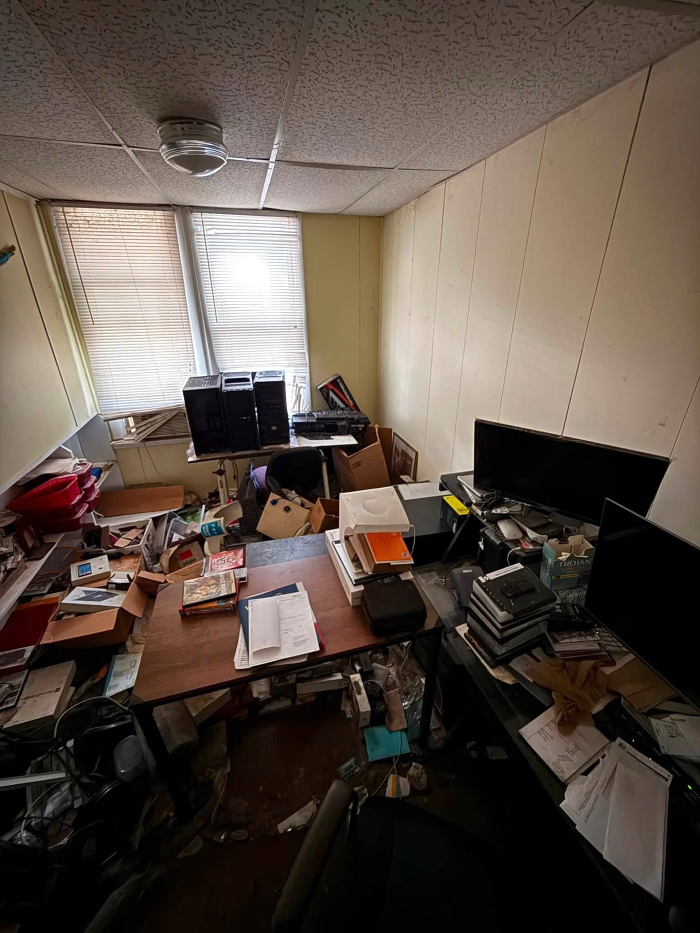 Cluttered room filled with boxes and electronics before a cleanout